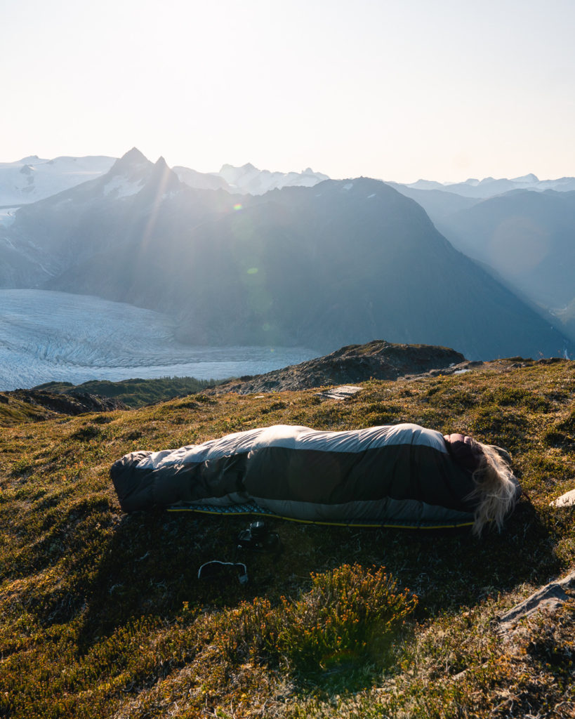 sleeping in sleeping bag in the mountains while solo backpacking